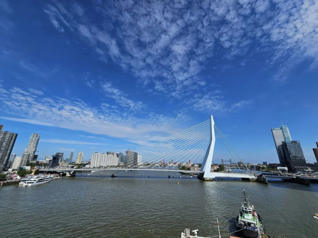 Cruising with Danny and Peter, P&O Ferries, Pride of Rotterdam, Spido, James Cook, Rotterdam, The Netherlands | A stunning Rotterdam mini cruise experience during World Port Days, starting from Beneluxhaven aboard the Pride of Rotterdam, surrounded by massive container ships and barges. Highlights include breathtaking views of the iconic Erasmus Bridge with its swan-like cables over the Nieuwe Maas river, and a sunset scene at Wilhelminakade with its modern skyscrapers and bustling port activities. The evening Spido harbor tour on the James Cook offered an illuminated view of Rotterdam's busy harbor, passing the majestic SS Rotterdam ship, a symbol of the city’s maritime heritage. The day concluded with a vibrant boat parade featuring illuminated vessels, followed by a spectacular fireworks display lighting up the Rotterdam skyline.