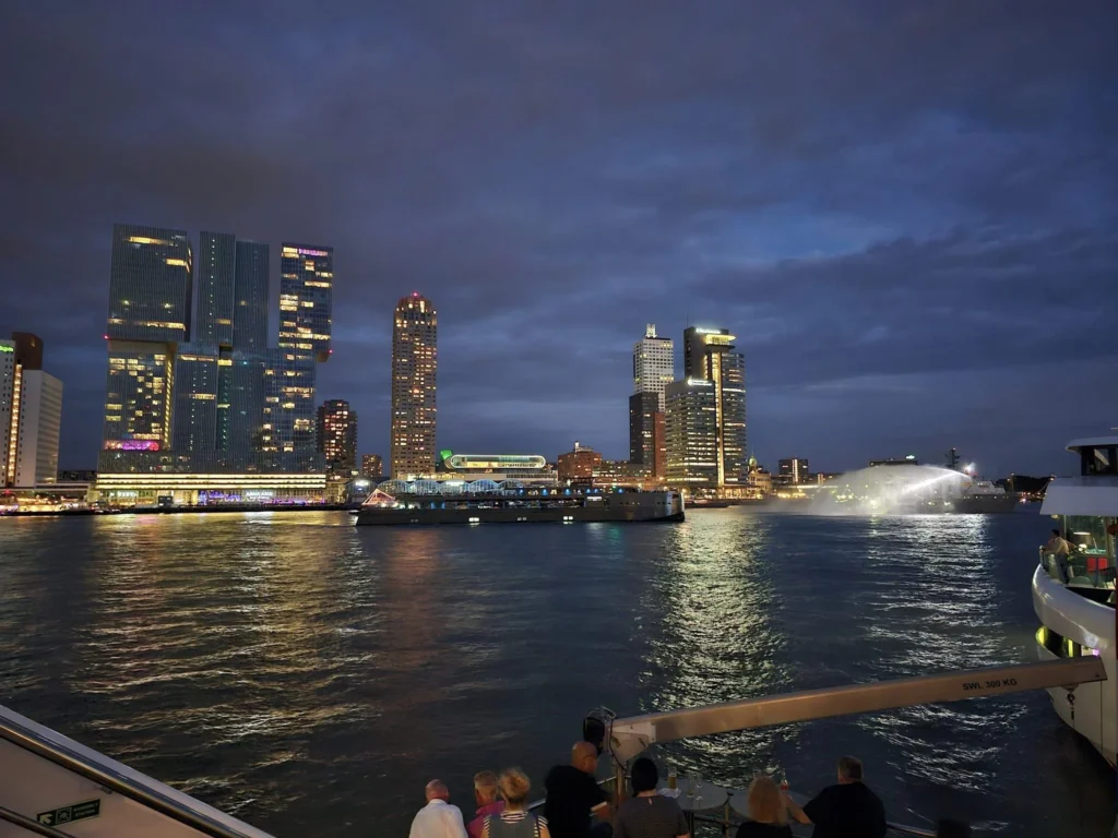 Cruising with Danny and Peter, P&O Ferries, Pride of Rotterdam, Spido, James Cook, Rotterdam, The Netherlands | A stunning Rotterdam mini cruise experience during World Port Days, starting from Beneluxhaven aboard the Pride of Rotterdam, surrounded by massive container ships and barges. Highlights include breathtaking views of the iconic Erasmus Bridge with its swan-like cables over the Nieuwe Maas river, and a sunset scene at Wilhelminakade with its modern skyscrapers and bustling port activities. The evening Spido harbor tour on the James Cook offered an illuminated view of Rotterdam's busy harbor, passing the majestic SS Rotterdam ship, a symbol of the city’s maritime heritage. The day concluded with a vibrant boat parade featuring illuminated vessels, followed by a spectacular fireworks display lighting up the Rotterdam skyline.