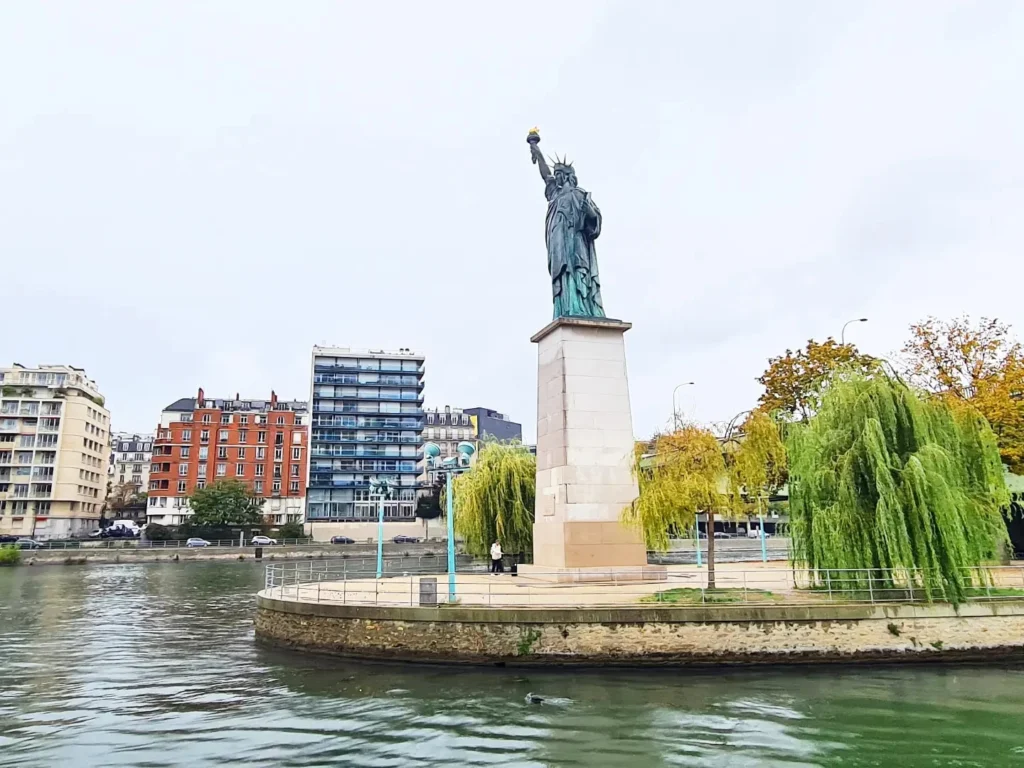 Cruising with Danny and Peter, Holland America Line, Rotterdam, Le Havre, Paris, France | A scenic view of the Eiffel Tower during a Paris day trip from Le Havre, showcasing the iconic landmark surrounded by blooming gardens, a relaxing Seine River cruise with passengers enjoying lunch, and hidden photo spots capturing the beauty of Paris.
