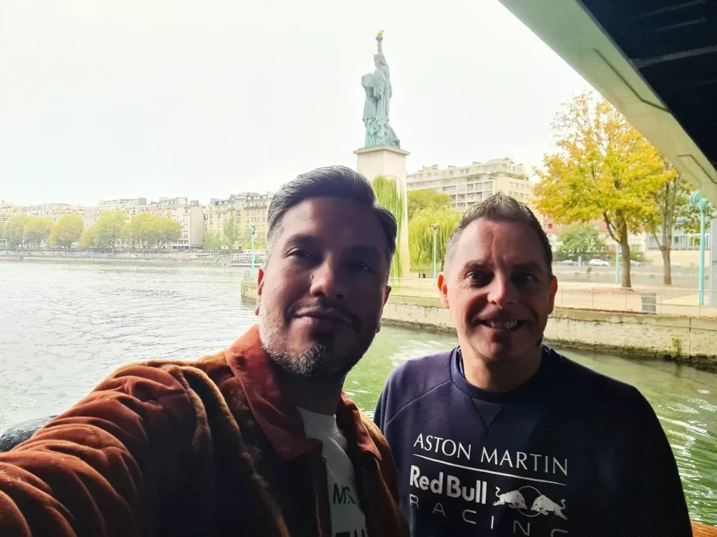 Cruising with Danny and Peter, Holland America Line, Rotterdam, Le Havre, Paris, France | A scenic view of the Eiffel Tower during a Paris day trip from Le Havre, showcasing the iconic landmark surrounded by blooming gardens, a relaxing Seine River cruise with passengers enjoying lunch, and hidden photo spots capturing the beauty of Paris.
