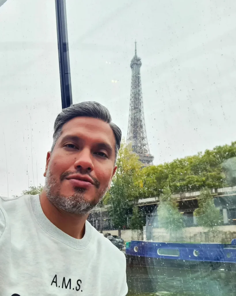 Cruising with Danny and Peter, Holland America Line, Rotterdam, Le Havre, Paris, France | A scenic view of the Eiffel Tower during a Paris day trip from Le Havre, showcasing the iconic landmark surrounded by blooming gardens, a relaxing Seine River cruise with passengers enjoying lunch, and hidden photo spots capturing the beauty of Paris.