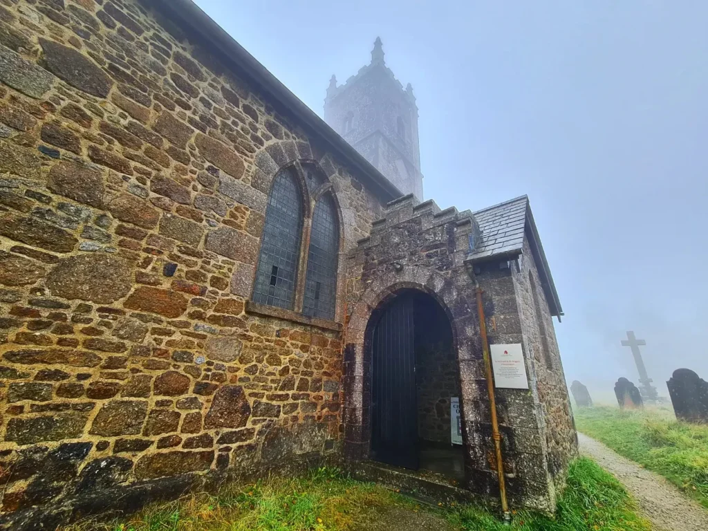 Cruising with Danny and Peter, Holland America Line, Rotterdam, Plymouth, England, Great Britain, United Kingdom | A foggy day in Plymouth Dartmoor showcases an eerie scene of historic churches and spooky graveyards, highlighting the enchanting beauty of Plymouth UK travel. A winding hiking trail through Dartmoor National Park is visible, surrounded by lush greenery and misty landscapes.