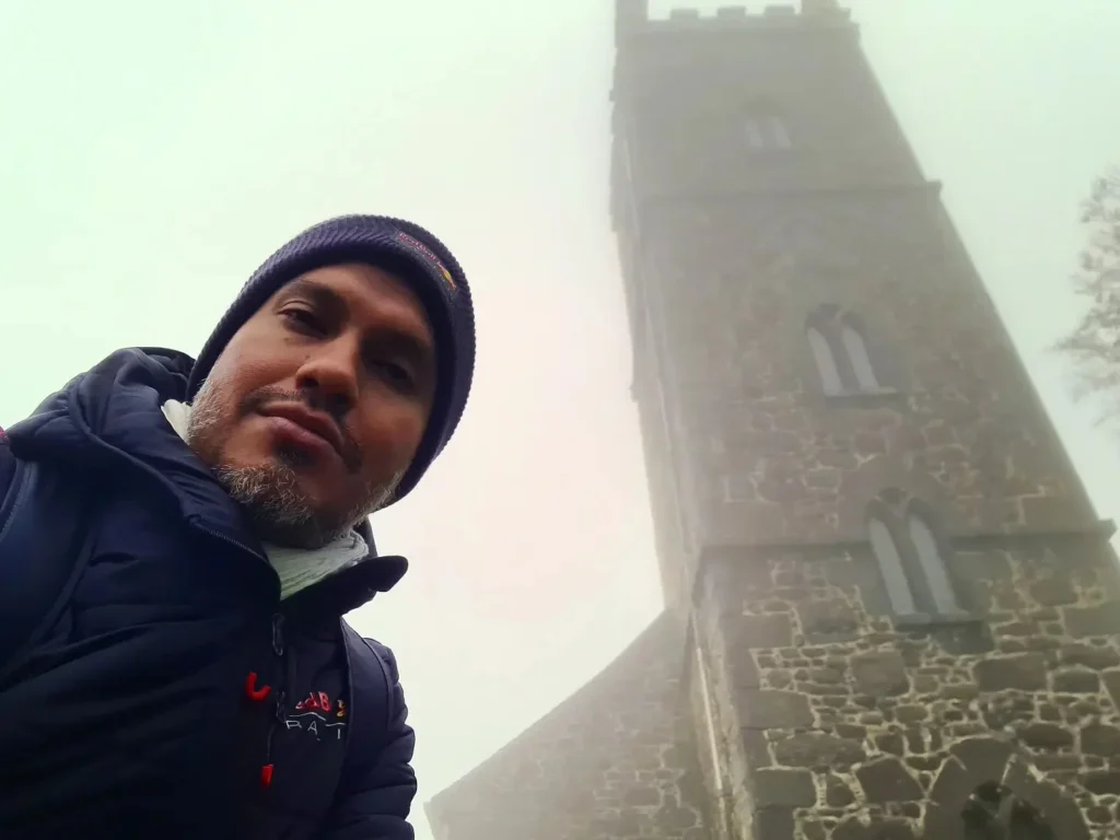 Cruising with Danny and Peter, Holland America Line, Rotterdam, Plymouth, England, Great Britain, United Kingdom | A foggy day in Plymouth Dartmoor showcases an eerie scene of historic churches and spooky graveyards, highlighting the enchanting beauty of Plymouth UK travel. A winding hiking trail through Dartmoor National Park is visible, surrounded by lush greenery and misty landscapes.