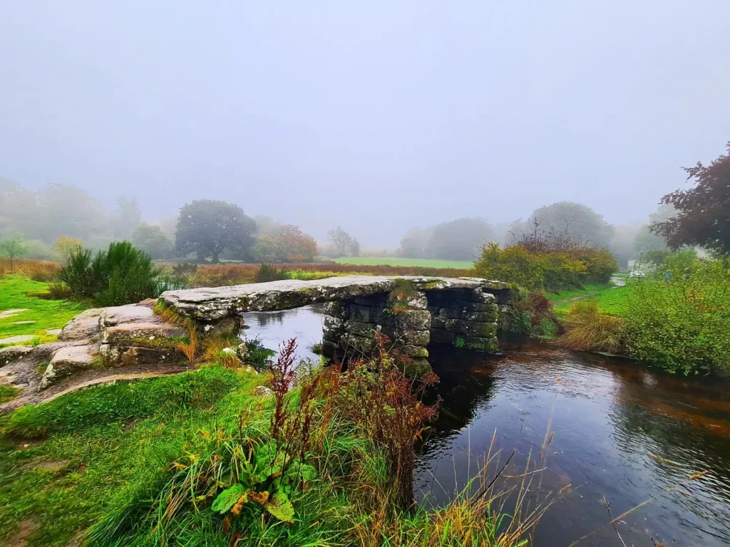 Cruising with Danny and Peter, Holland America Line, Rotterdam, Plymouth, England, Great Britain, United Kingdom | A foggy day in Plymouth Dartmoor showcases an eerie scene of historic churches and spooky graveyards, highlighting the enchanting beauty of Plymouth UK travel. A winding hiking trail through Dartmoor National Park is visible, surrounded by lush greenery and misty landscapes.