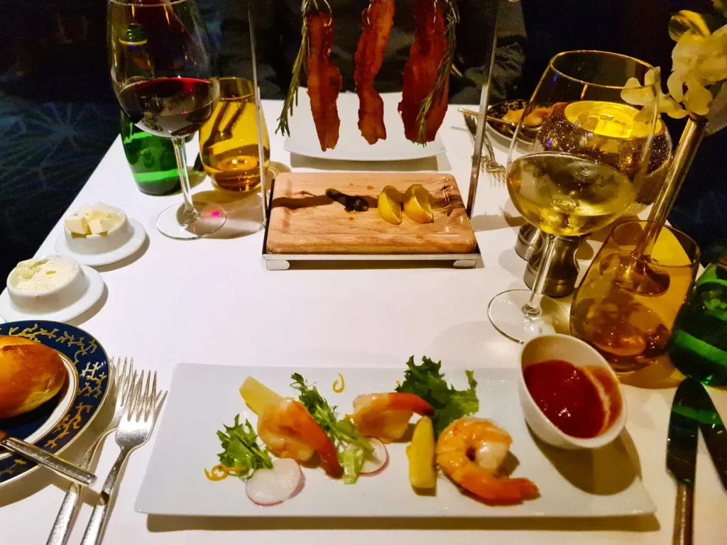 Cruising with Danny and Peter, Holland America Line, Rotterdam, Atlantic Ocean, Sea Day | Guests enjoying the first sea day on the Holland America Line 150th Anniversary Cruise aboard the Rotterdam, featuring scenic Atlantic Ocean views, elegant dining at the Pinnacle Grill, onboard events like the Mariners Society meeting on the Lido Deck, and morning breakfast selections. A memorable day at sea during Holland America Line’s milestone voyage celebration.