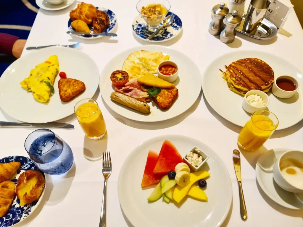 Cruising with Danny and Peter, Holland America Line, Rotterdam, Atlantic Ocean, Sea Day | Guests enjoying the first sea day on the Holland America Line 150th Anniversary Cruise aboard the Rotterdam, featuring scenic Atlantic Ocean views, elegant dining at the Pinnacle Grill, onboard events like the Mariners Society meeting on the Lido Deck, and morning breakfast selections. A memorable day at sea during Holland America Line’s milestone voyage celebration.