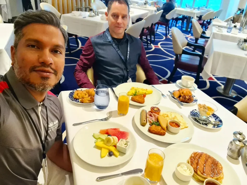 Cruising with Danny and Peter, Holland America Line, Rotterdam, Atlantic Ocean, Sea Day | Guests enjoying the first sea day on the Holland America Line 150th Anniversary Cruise aboard the Rotterdam, featuring scenic Atlantic Ocean views, elegant dining at the Pinnacle Grill, onboard events like the Mariners Society meeting on the Lido Deck, and morning breakfast selections. A memorable day at sea during Holland America Line’s milestone voyage celebration.