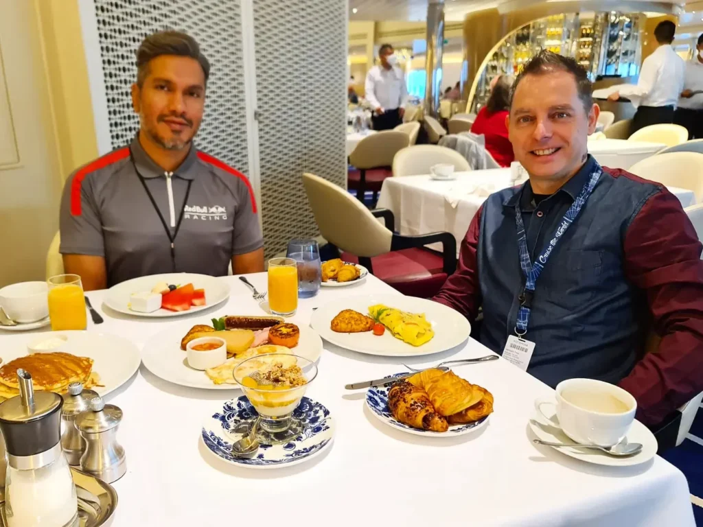 Cruising with Danny and Peter, Holland America Line, Rotterdam, Atlantic Ocean, Sea Day | Guests enjoying the first sea day on the Holland America Line 150th Anniversary Cruise aboard the Rotterdam, featuring scenic Atlantic Ocean views, elegant dining at the Pinnacle Grill, onboard events like the Mariners Society meeting on the Lido Deck, and morning breakfast selections. A memorable day at sea during Holland America Line’s milestone voyage celebration.