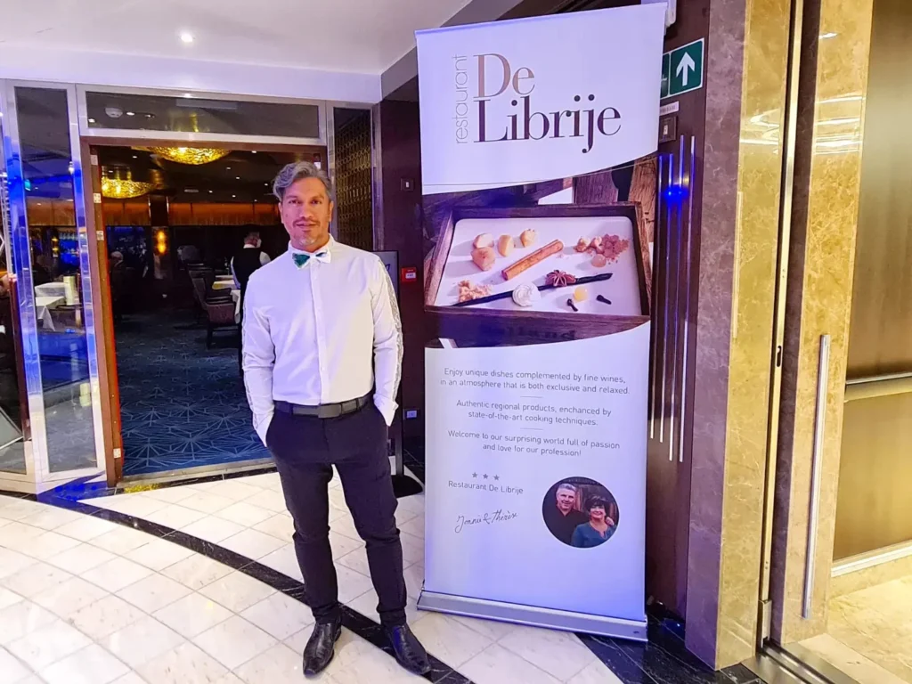 Cruising with Danny and Peter, Holland America Line, Rotterdam, Atlantic Ocean, Sea Day | A beautifully plated dish from the Taste of De Librije dinner aboard the Rotterdam, featuring Jonnie Boer cuisine, including caviar egg, king fish, and oysters, paired with Cloudy Bay Sauvignon Blanc. The elegant dining setup highlights the luxurious atmosphere of Holland America Line's Pinnacle Grill during this exquisite transatlantic cruise dinner.