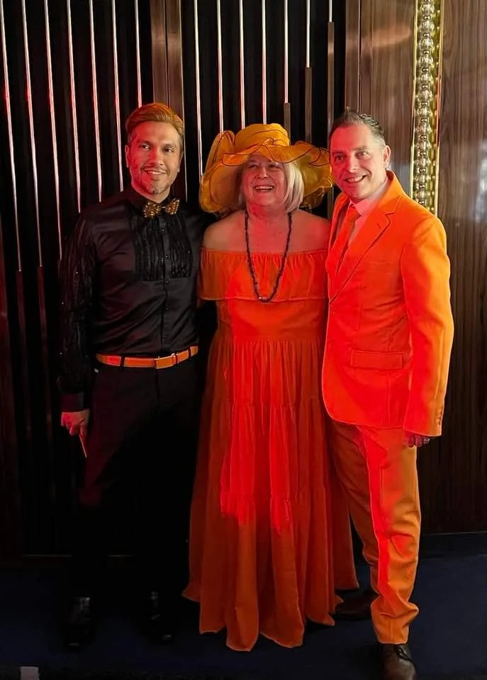 Cruising with Danny and Peter, Holland America Line, Rotterdam, Atlantic Ocean, Sea Day | Guests celebrating the Orange Party Holland America 150th Anniversary aboard the MS Rotterdam, enjoying live music, Dutch treats like Kapsalon, Poffertjes, and Kleine Appeltaart, while wearing orange attire in honor of Dutch heritage and the Holland America anniversary party.