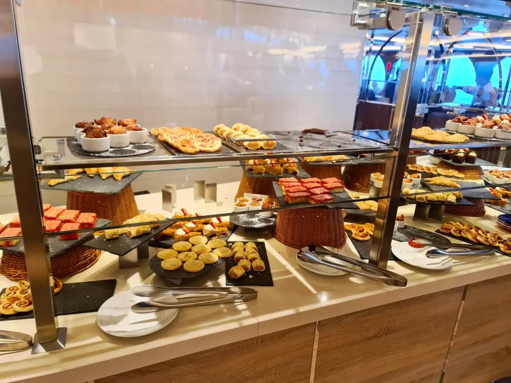 Cruising with Danny and Peter, Holland America Line, Rotterdam, Atlantic Ocean, Sea Day | Guests celebrating the Orange Party Holland America 150th Anniversary aboard the MS Rotterdam, enjoying live music, Dutch treats like Kapsalon, Poffertjes, and Kleine Appeltaart, while wearing orange attire in honor of Dutch heritage and the Holland America anniversary party.