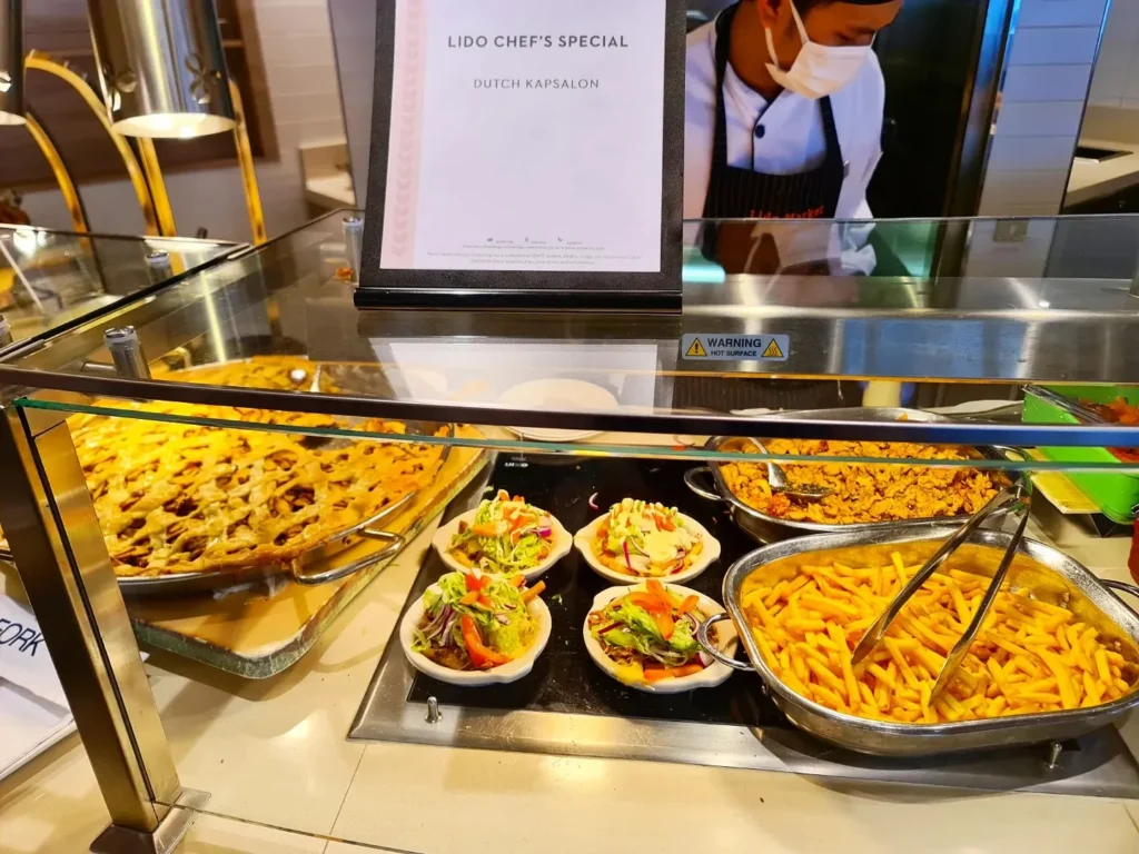 Cruising with Danny and Peter, Holland America Line, Rotterdam, Atlantic Ocean, Sea Day | Guests celebrating the Orange Party Holland America 150th Anniversary aboard the MS Rotterdam, enjoying live music, Dutch treats like Kapsalon, Poffertjes, and Kleine Appeltaart, while wearing orange attire in honor of Dutch heritage and the Holland America anniversary party.