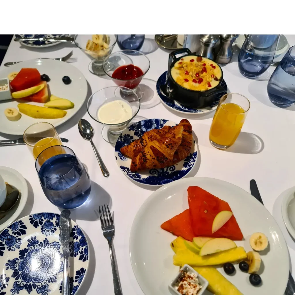 Cruising with Danny and Peter, Holland America Line, Rotterdam, Atlantic Ocean, Sea Day | Guests celebrating the Orange Party Holland America 150th Anniversary aboard the MS Rotterdam, enjoying live music, Dutch treats like Kapsalon, Poffertjes, and Kleine Appeltaart, while wearing orange attire in honor of Dutch heritage and the Holland America anniversary party.