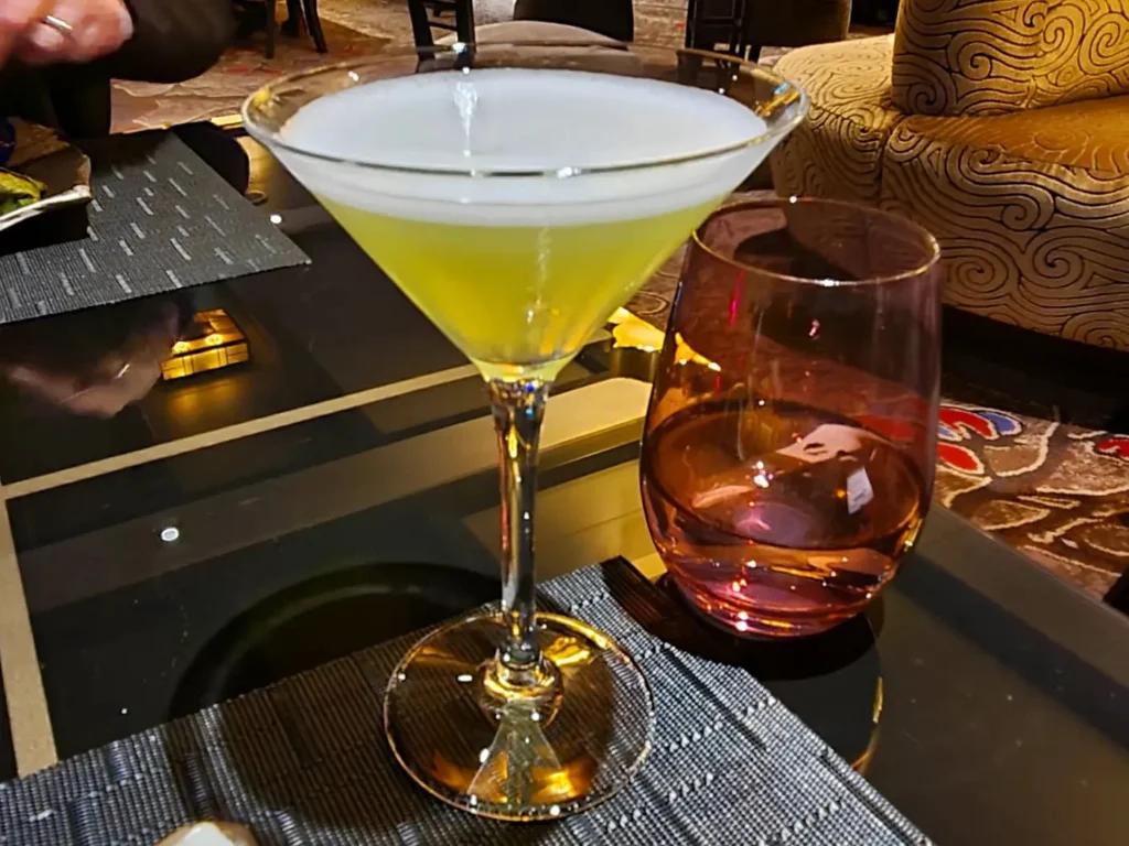 Cruising with Danny and Peter, Holland America Line, Rotterdam, Atlantic Ocean, Sea Day | Indonesian Rijsttafel at Sea served at the Tamarind restaurant aboard the Rotterdam cruise, showcasing vibrant dishes including Soto Ayam Madura, Nasi Goreng, and Pork Sate, alongside a Wasabi martini and Jalapeño martini, highlighting the unique culinary experience and ambiance of specialty restaurants on the cruise.