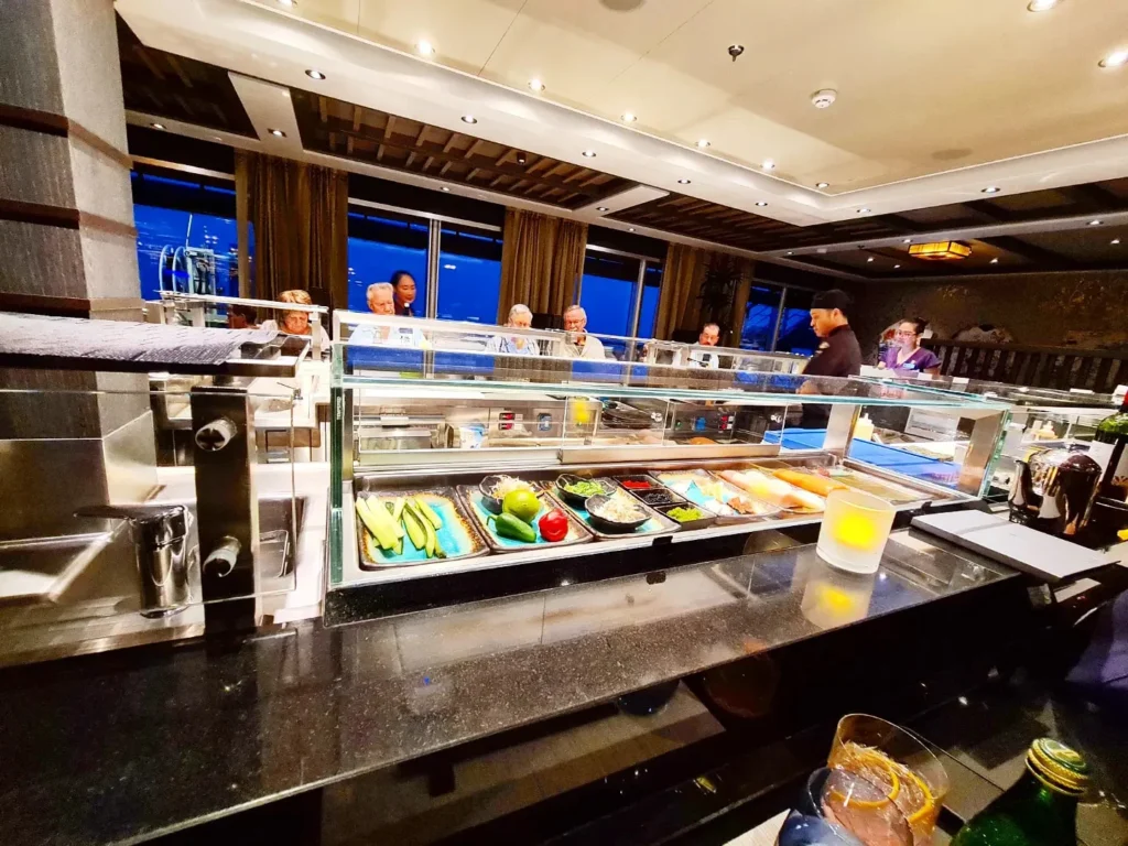 Cruising with Danny and Peter, Holland America Line, Rotterdam, Atlantic Ocean, Sea Day | A luxurious Sushi night MS Rotterdam experience aboard Holland America Line, featuring a variety of fresh sushi dishes like Hamachi, scallop ceviche, seared albacore tuna, and fried soft shell crab sushi, accompanied by cocktails at the Oceanview sushi restaurant with stunning ocean views, showcasing the Best sushi at sea during a memorable Sushi dining aboard MS Rotterdam.