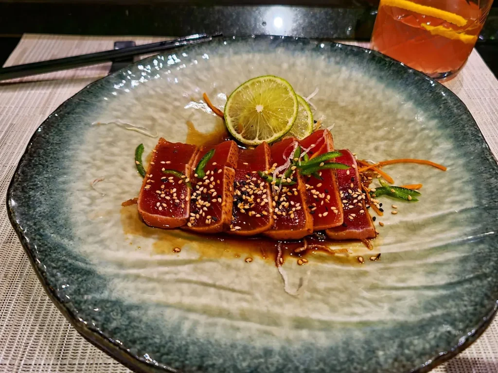 Cruising with Danny and Peter, Holland America Line, Rotterdam, Atlantic Ocean, Sea Day | A luxurious Sushi night MS Rotterdam experience aboard Holland America Line, featuring a variety of fresh sushi dishes like Hamachi, scallop ceviche, seared albacore tuna, and fried soft shell crab sushi, accompanied by cocktails at the Oceanview sushi restaurant with stunning ocean views, showcasing the Best sushi at sea during a memorable Sushi dining aboard MS Rotterdam.