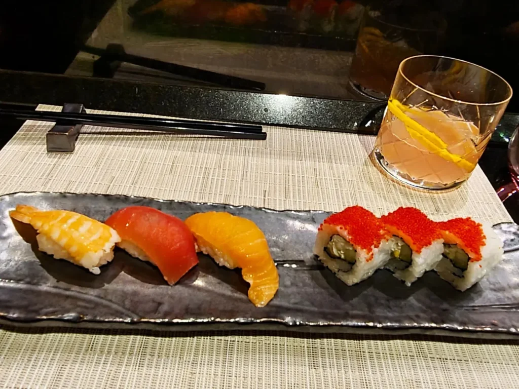 Cruising with Danny and Peter, Holland America Line, Rotterdam, Atlantic Ocean, Sea Day | A luxurious Sushi night MS Rotterdam experience aboard Holland America Line, featuring a variety of fresh sushi dishes like Hamachi, scallop ceviche, seared albacore tuna, and fried soft shell crab sushi, accompanied by cocktails at the Oceanview sushi restaurant with stunning ocean views, showcasing the Best sushi at sea during a memorable Sushi dining aboard MS Rotterdam.