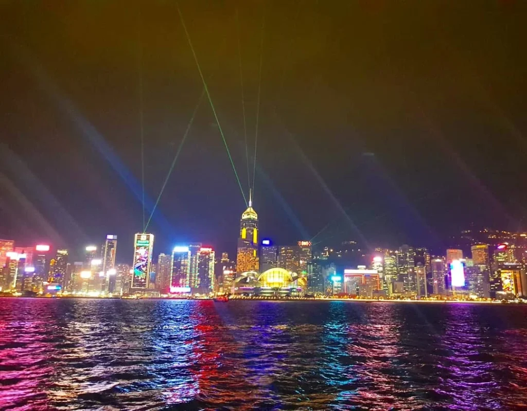 Cruising with Danny and Peter, Holland America Line, Westerdam, Hong Kong, China | Stunning view of the Symphony of Lights at Victoria Harbor Hong Kong, showcasing the Hong Kong skyline illumination with vibrant lights dancing across Victoria Harbour. A Harbor night light display featuring synchronized music, laser beams, and breathtaking visuals. The iconic Victoria Harbour waterfront show highlights the Hong Kong laser show and Skyscraper light show Hong Kong, creating a mesmerizing Hong Kong evening light spectacle that reflects the city's cultural richness. Experience the City lights performance Hong Kong as part of this Hong Kong cultural light show.