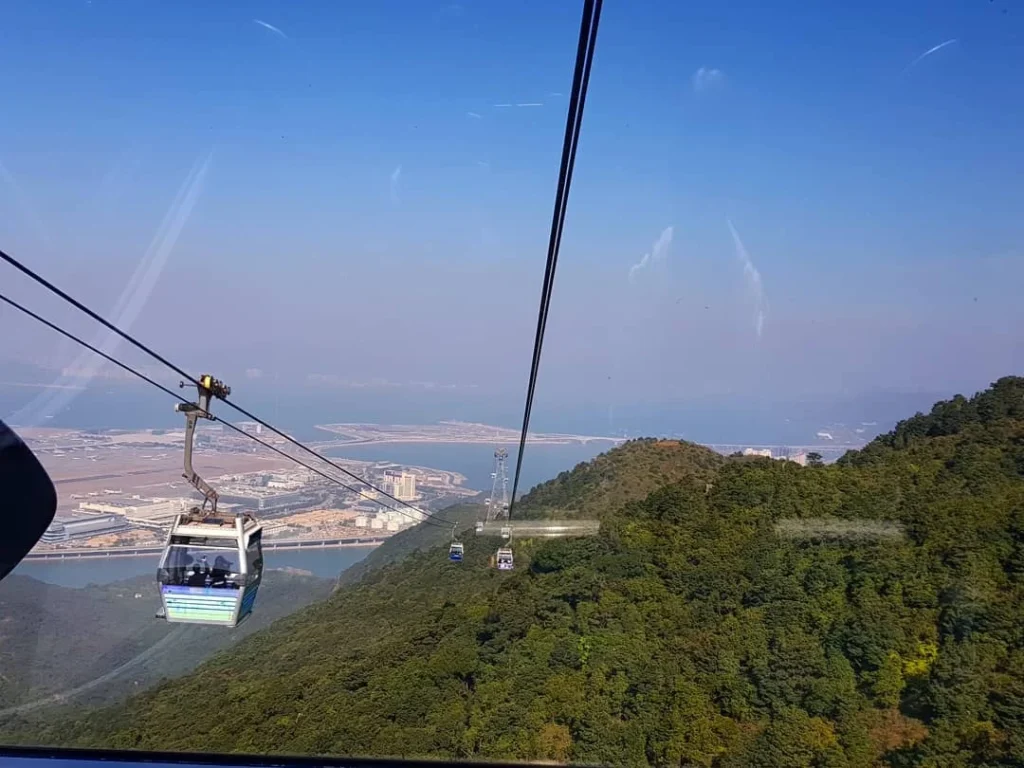 Cruising with Danny and Peter, Holland America Line, Westerdam, Hong Kong, China | A breathtaking view from Ngong Ping 360 cable car showcasing lush landscapes and the South China Sea, capturing the serene beauty of Lantau Island. A majestic shot of the Tian Tan Buddha, surrounded by the tranquil Po Lin Monastery, illustrating the cultural richness of Hong Kong. The vibrant skyline of Hong Kong from Victoria Peak, highlighting the dynamic cityscape during sunset, with twinkling lights illuminating the urban landscape, representing the perfect blend of nature and urbanity in these unforgettable Hong Kong Adventures.