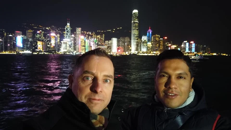 Cruising with Danny and Peter, Holland America Line, Westerdam, Hong Kong, China | A vibrant scene of Hong Kong's skyline during sunset, showcasing the majestic Westerdam cruise ship docked at the harbor, with tourists exploring the iconic Man Mo Temple, highlighting the cultural richness and luxury of a Hong Kong cruise experience.