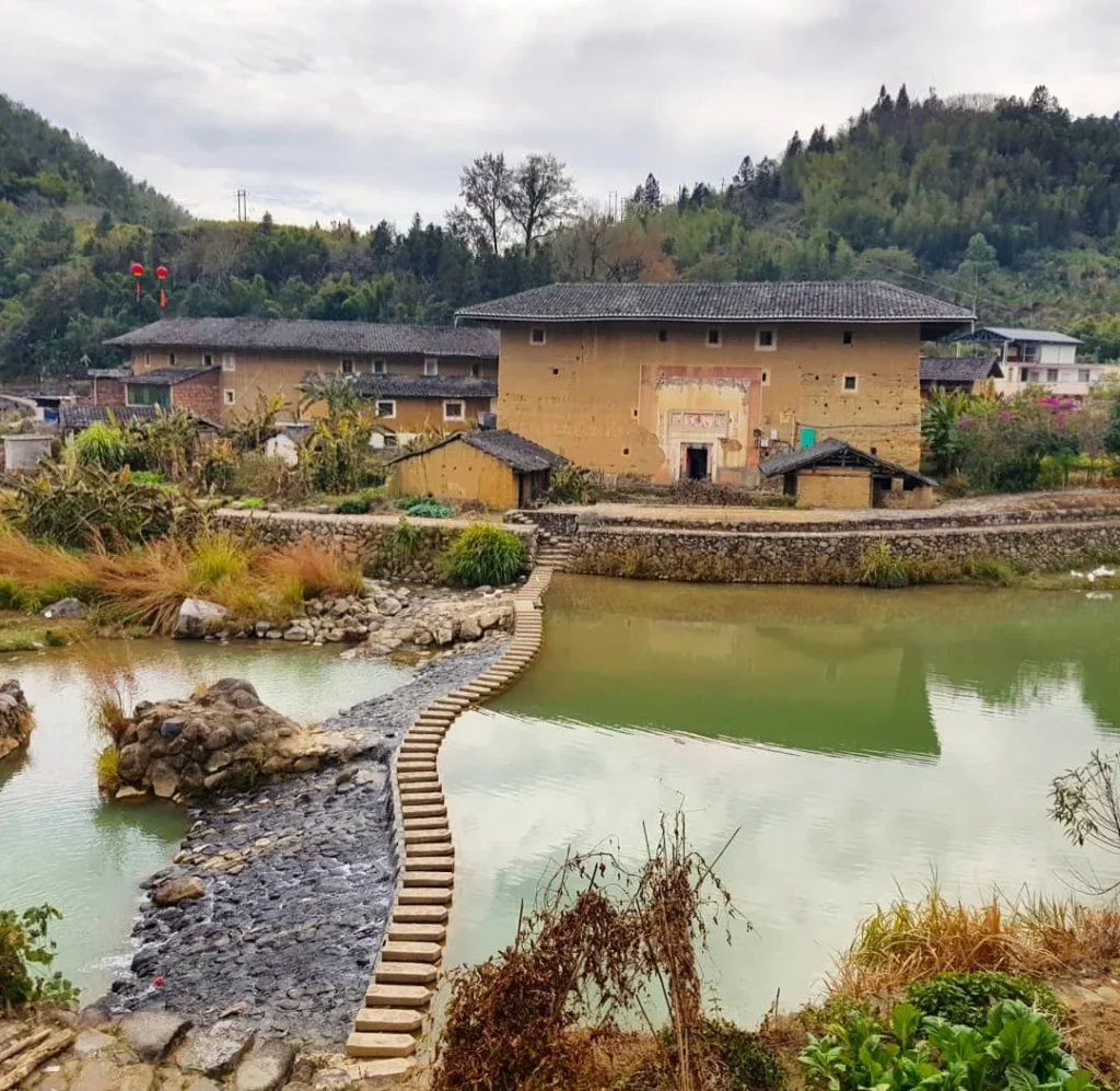 Xiamen Cruise Port: Our Complete Guide + Insider Tips 2026 (Visited Once in 2019 by Danny and Peter) 8 Cruising with Danny and Peter, Holland America Line, Westerdam, Xiamen, China | Exterior and interior views of Fujian Tulou, featuring traditional Hakka earthen architecture and intricate wooden carvings. Showcasing scenic Fujian Province landscapes and communal living structures at the UNESCO World Heritage site in Xiamen.