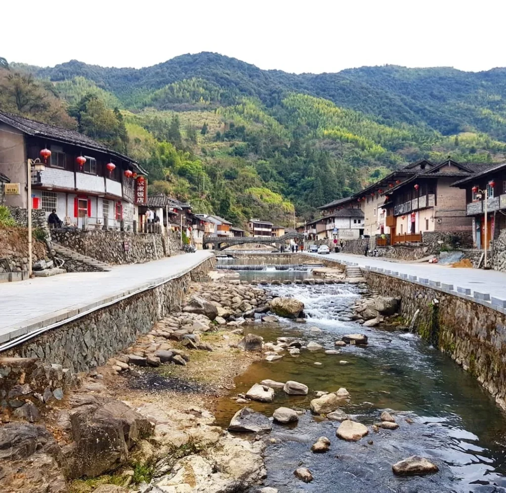 Xiamen Cruise Port: Our Complete Guide + Insider Tips 2026 (Visited Once in 2019 by Danny and Peter) 12 Cruising with Danny and Peter, Holland America Line, Westerdam, Xiamen, China | Exterior and interior views of Fujian Tulou, featuring traditional Hakka earthen architecture and intricate wooden carvings. Showcasing scenic Fujian Province landscapes and communal living structures at the UNESCO World Heritage site in Xiamen.