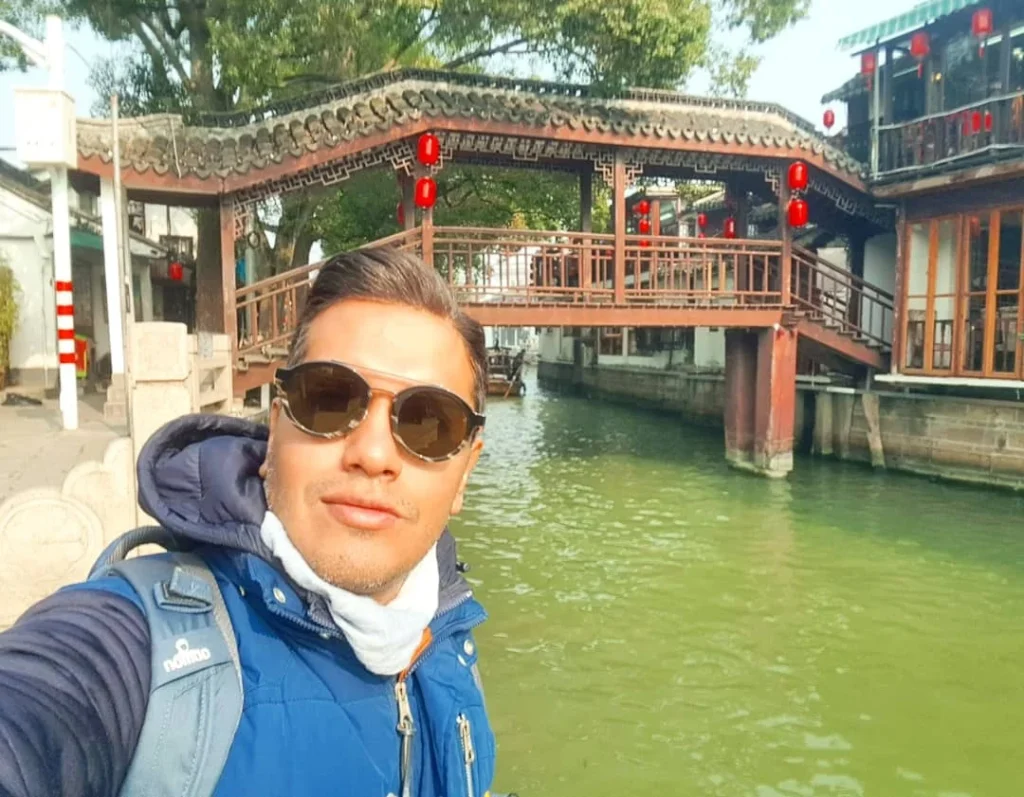 Cruising with Danny and Peter, Holland America Line, Westerdam, Shanghai, China | Serene canal view in Shanghai Watertown, showcasing traditional Chinese architecture and vibrant red lanterns, with a scenic boat ride through historic waterways and lush gardens, capturing the timeless charm and cultural heritage of Shanghai's ancient town.