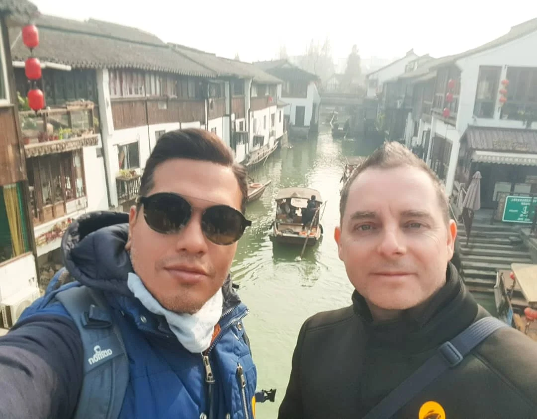 Cruising with Danny and Peter, Holland America Line, Westerdam, Shanghai, China | Serene canal view in Shanghai Watertown, showcasing traditional Chinese architecture and vibrant red lanterns, with a scenic boat ride through historic waterways and lush gardens, capturing the timeless charm and cultural heritage of Shanghai's ancient town.