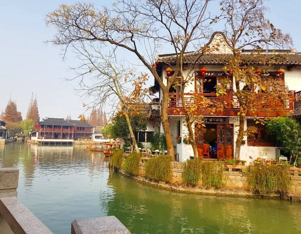 Cruising with Danny and Peter, Holland America Line, Westerdam, Shanghai, China | Serene canal view in Shanghai Watertown, showcasing traditional Chinese architecture and vibrant red lanterns, with a scenic boat ride through historic waterways and lush gardens, capturing the timeless charm and cultural heritage of Shanghai's ancient town.