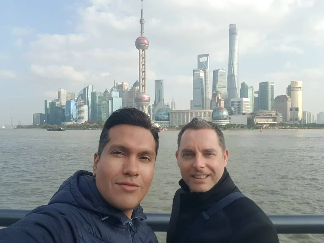 Cruising with Danny and Peter, Holland America Line, Westerdam, Shanghai, China | A guide leading a group through historic landmarks in Shanghai, showcasing the vibrant cityscape, modern skyscrapers, and traditional architecture. The group enjoys a Chinese tea ceremony, tasting various teas in a serene teahouse, capturing the essence of an unforgettable Shanghai Private Tour and Tea Tasting Experience.