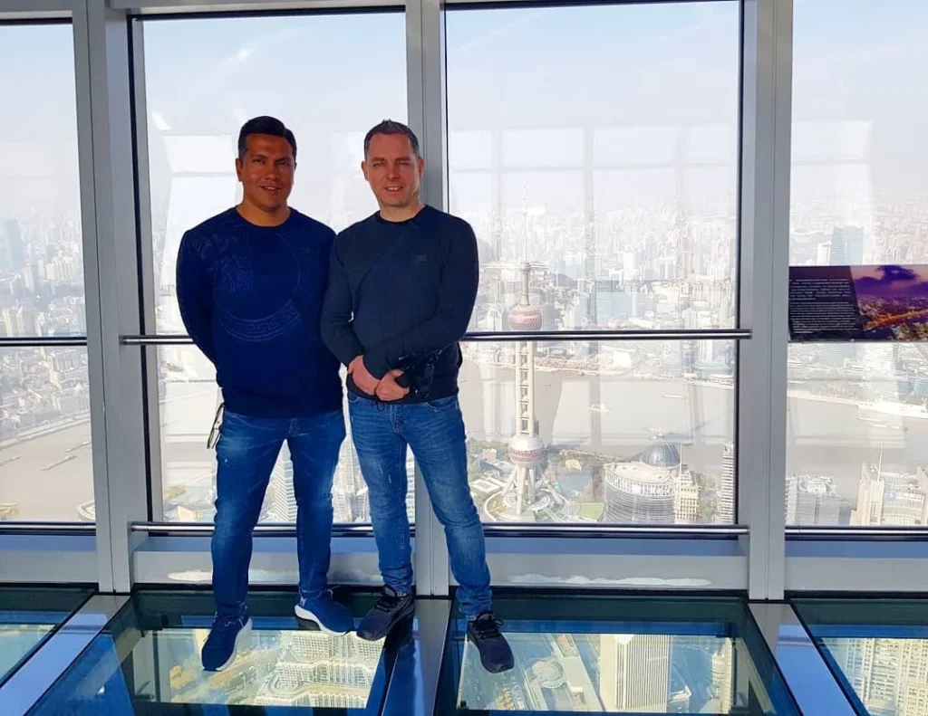 Cruising with Danny and Peter, Holland America Line, Westerdam, Shanghai, China | A guide leading a group through historic landmarks in Shanghai, showcasing the vibrant cityscape, modern skyscrapers, and traditional architecture. The group enjoys a Chinese tea ceremony, tasting various teas in a serene teahouse, capturing the essence of an unforgettable Shanghai Private Tour and Tea Tasting Experience.