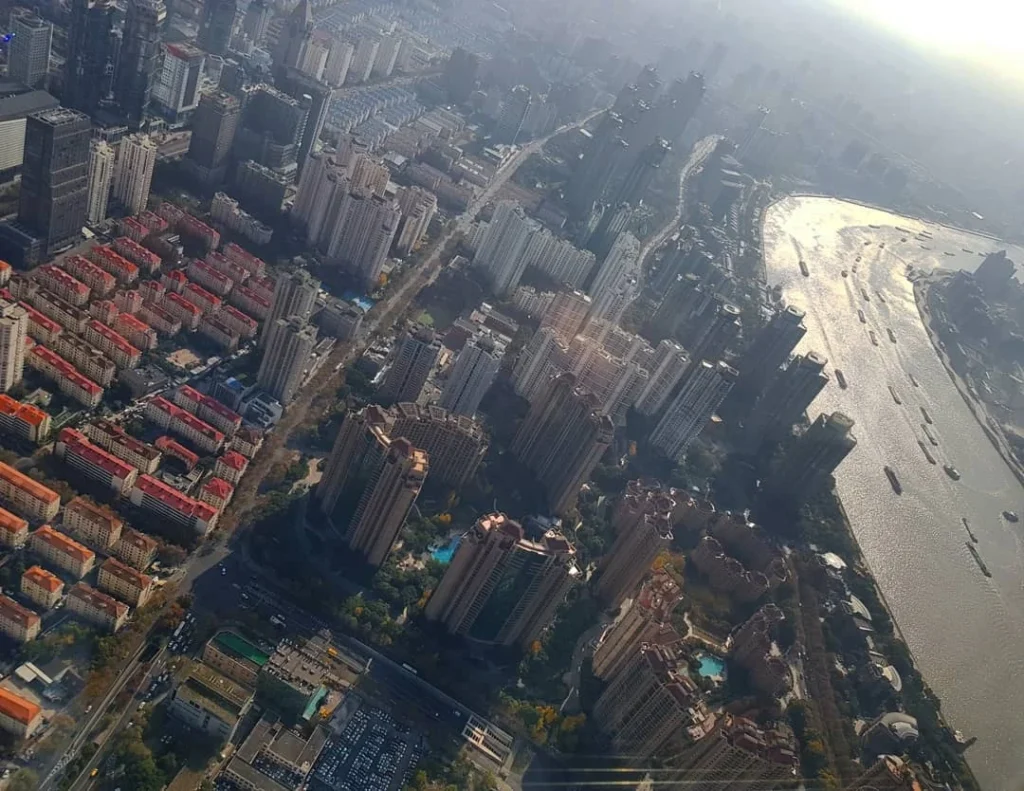 Cruising with Danny and Peter, Holland America Line, Westerdam, Shanghai, China | A guide leading a group through historic landmarks in Shanghai, showcasing the vibrant cityscape, modern skyscrapers, and traditional architecture. The group enjoys a Chinese tea ceremony, tasting various teas in a serene teahouse, capturing the essence of an unforgettable Shanghai Private Tour and Tea Tasting Experience.
