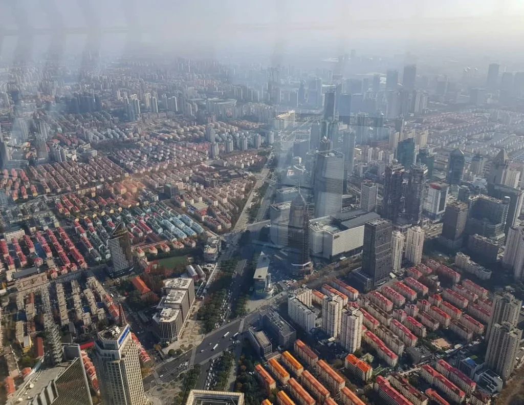 Cruising with Danny and Peter, Holland America Line, Westerdam, Shanghai, China | A guide leading a group through historic landmarks in Shanghai, showcasing the vibrant cityscape, modern skyscrapers, and traditional architecture. The group enjoys a Chinese tea ceremony, tasting various teas in a serene teahouse, capturing the essence of an unforgettable Shanghai Private Tour and Tea Tasting Experience.