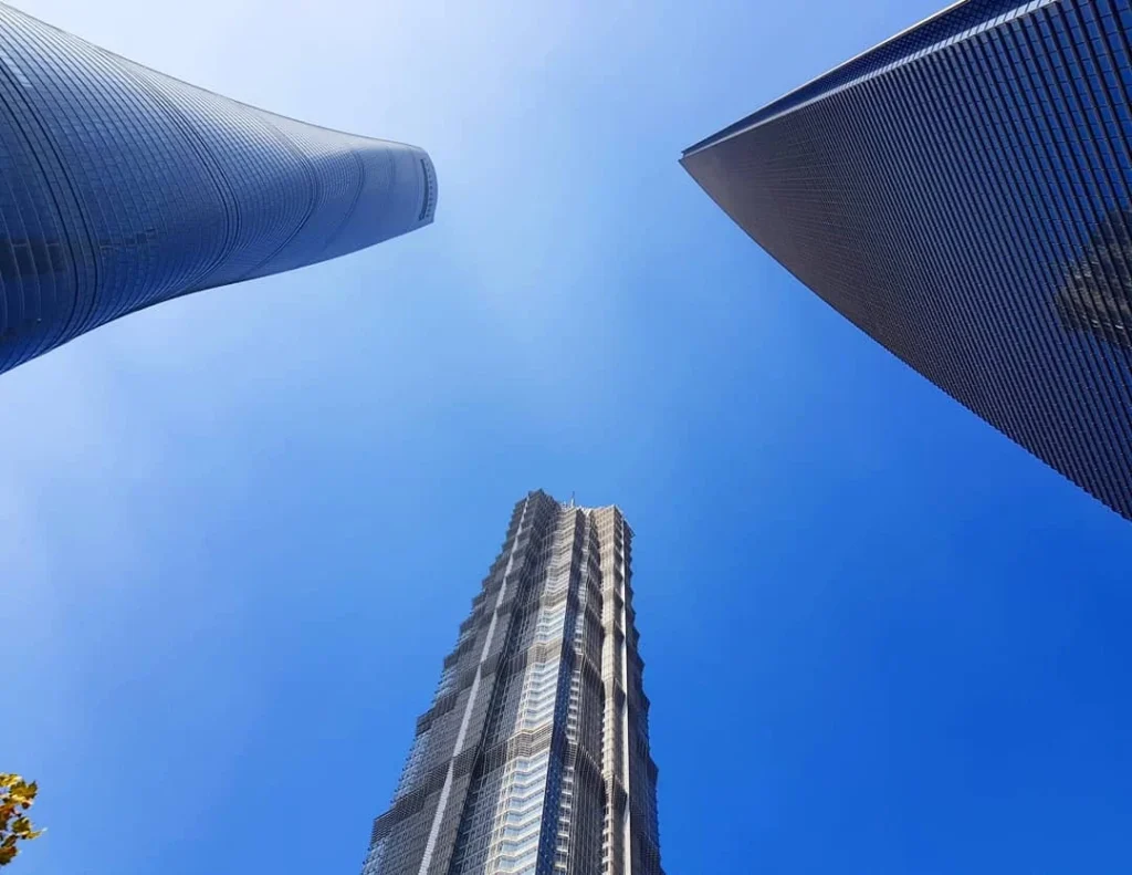 Cruising with Danny and Peter, Holland America Line, Westerdam, Shanghai, China | A guide leading a group through historic landmarks in Shanghai, showcasing the vibrant cityscape, modern skyscrapers, and traditional architecture. The group enjoys a Chinese tea ceremony, tasting various teas in a serene teahouse, capturing the essence of an unforgettable Shanghai Private Tour and Tea Tasting Experience.