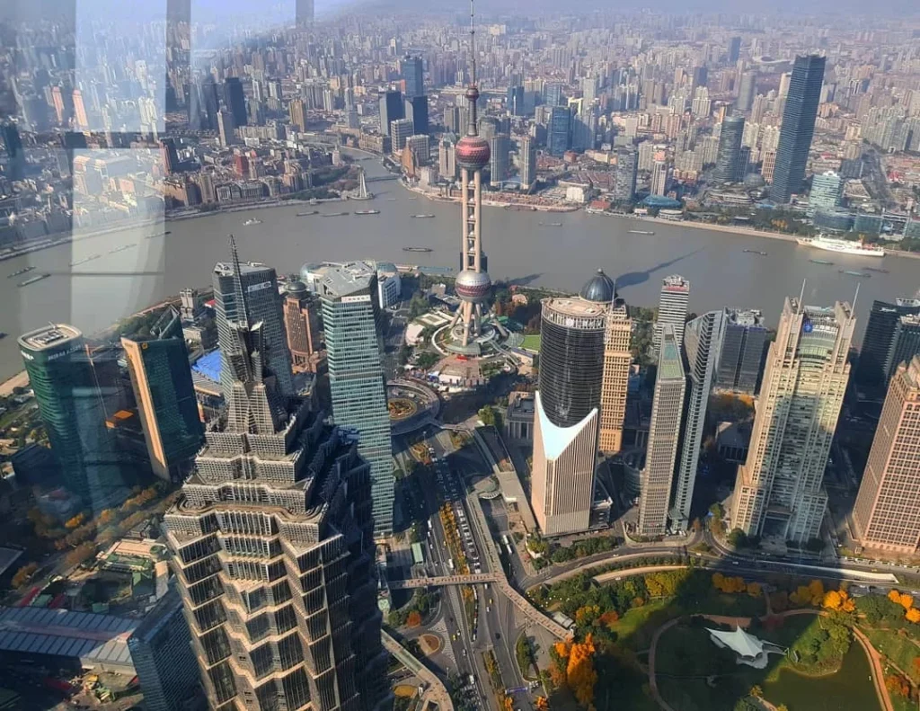 Cruising with Danny and Peter, Holland America Line, Westerdam, Shanghai, China | A guide leading a group through historic landmarks in Shanghai, showcasing the vibrant cityscape, modern skyscrapers, and traditional architecture. The group enjoys a Chinese tea ceremony, tasting various teas in a serene teahouse, capturing the essence of an unforgettable Shanghai Private Tour and Tea Tasting Experience.