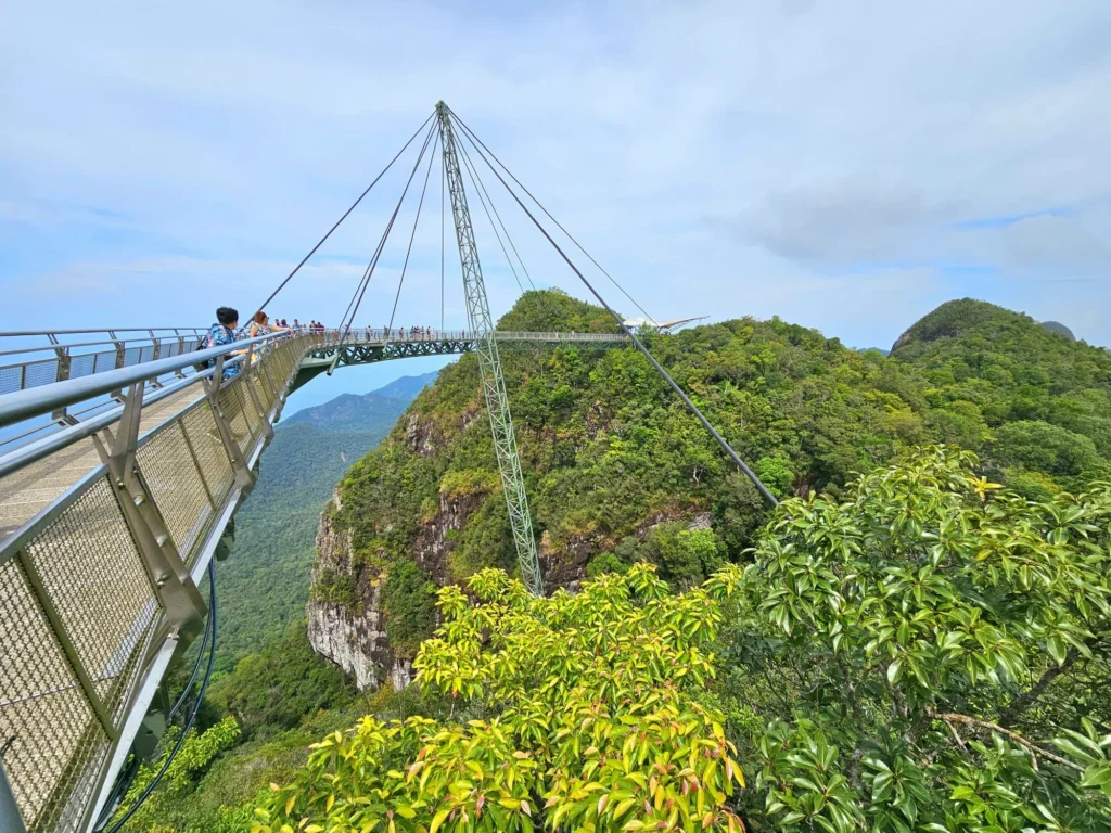 Cruising with Danny and Peter, Holland America Line, Westerdam, Porto Malai, Langkawi, Malaysia | Scenic views of Porto Malai Marina with yachts, private boat cruising through Kilim Karst Geoforest's mangroves, majestic eagles soaring above, and panoramic vistas from the Langkawi Sky Bridge and Cable Car overlooking lush rainforests and the Andaman Sea during a Langkawi Day Trip.