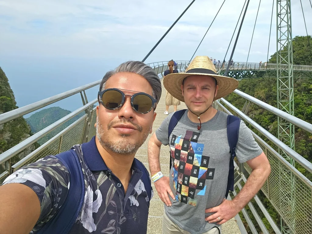 Cruising with Danny and Peter, Holland America Line, Westerdam, Porto Malai, Langkawi, Malaysia | Scenic views of Porto Malai Marina with yachts, private boat cruising through Kilim Karst Geoforest's mangroves, majestic eagles soaring above, and panoramic vistas from the Langkawi Sky Bridge and Cable Car overlooking lush rainforests and the Andaman Sea during a Langkawi Day Trip.