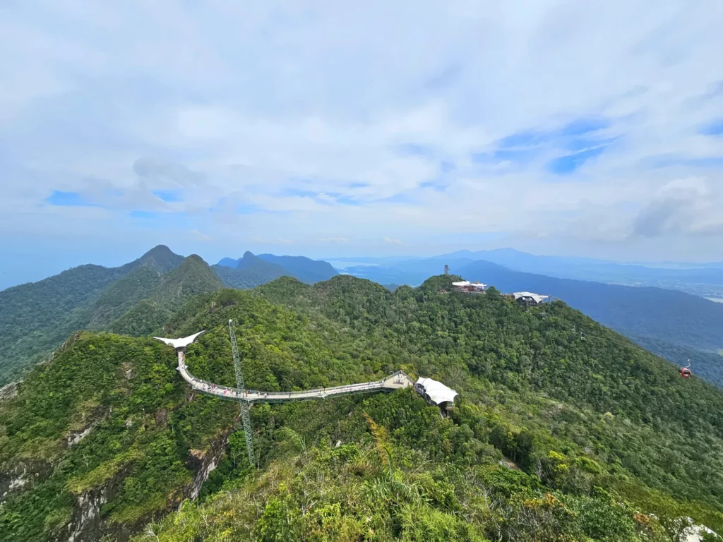 Cruising with Danny and Peter, Holland America Line, Westerdam, Porto Malai, Langkawi, Malaysia | Scenic views of Porto Malai Marina with yachts, private boat cruising through Kilim Karst Geoforest's mangroves, majestic eagles soaring above, and panoramic vistas from the Langkawi Sky Bridge and Cable Car overlooking lush rainforests and the Andaman Sea during a Langkawi Day Trip.