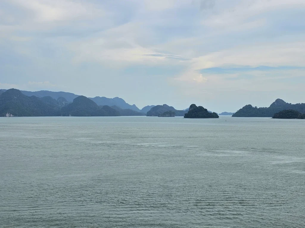 Cruising with Danny and Peter, Holland America Line, Westerdam, Porto Malai, Langkawi, Malaysia | Scenic views of Porto Malai Marina with yachts, private boat cruising through Kilim Karst Geoforest's mangroves, majestic eagles soaring above, and panoramic vistas from the Langkawi Sky Bridge and Cable Car overlooking lush rainforests and the Andaman Sea during a Langkawi Day Trip.
