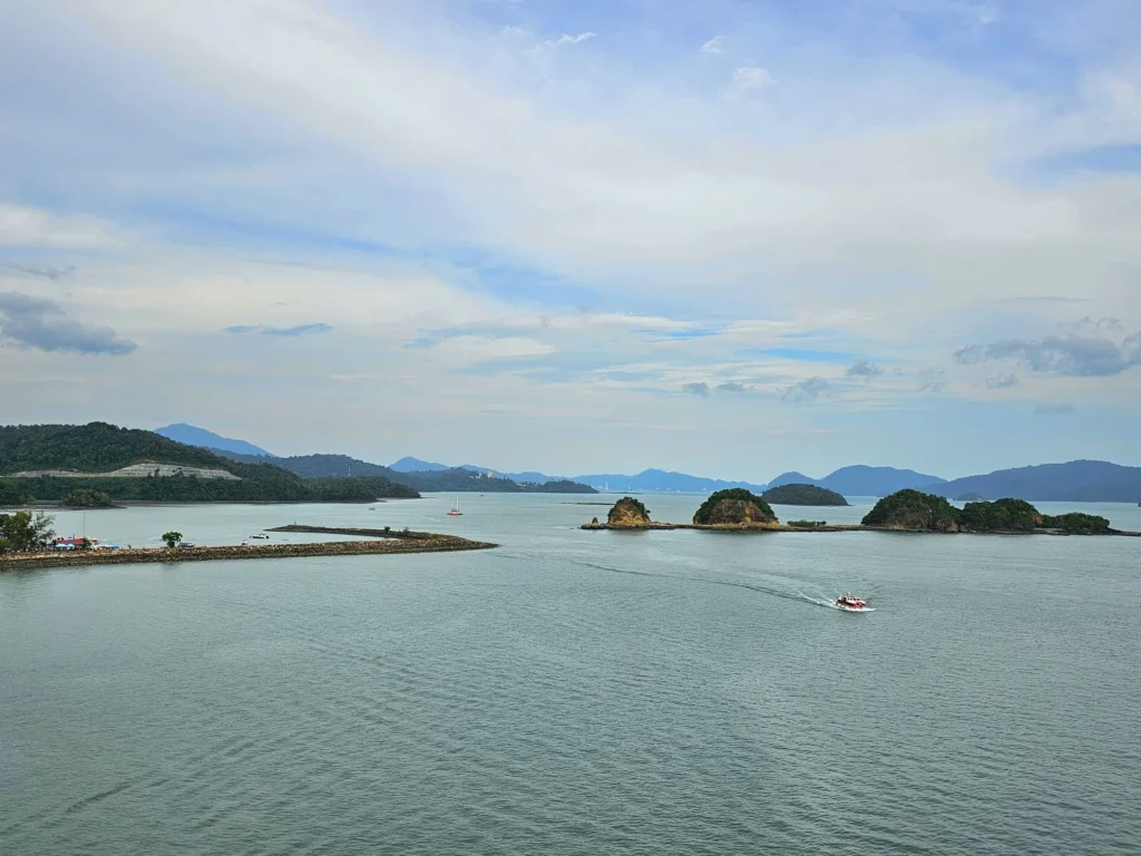 Cruising with Danny and Peter, Holland America Line, Westerdam, Porto Malai, Langkawi, Malaysia | Scenic views of Porto Malai Marina with yachts, private boat cruising through Kilim Karst Geoforest's mangroves, majestic eagles soaring above, and panoramic vistas from the Langkawi Sky Bridge and Cable Car overlooking lush rainforests and the Andaman Sea during a Langkawi Day Trip.