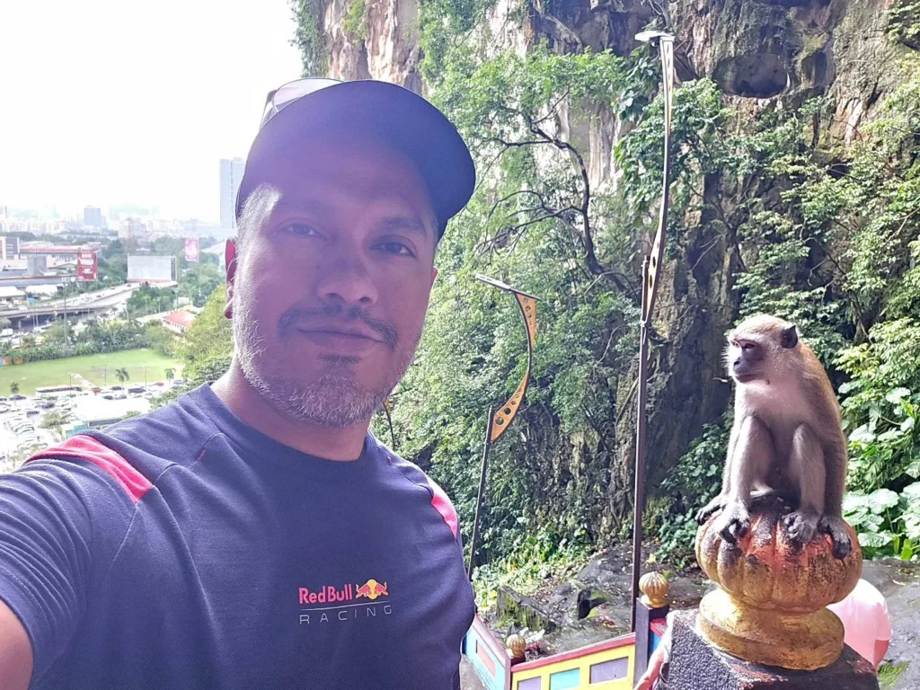 Cruising with Danny and Peter, Holland America Line, Westerdam, Port Kelang, Kuala Lumpur, Malaysia | Port Klang harbor bustling with cargo ships, vibrant staircase leading up to Batu Caves with colorful Hindu art, iconic Petronas Twin Towers towering over Kuala Lumpur’s skyline, panoramic view from KL Tower observation deck showcasing the cityscape, and historical artifacts at the National Museum illustrating Malaysia’s cultural heritage.