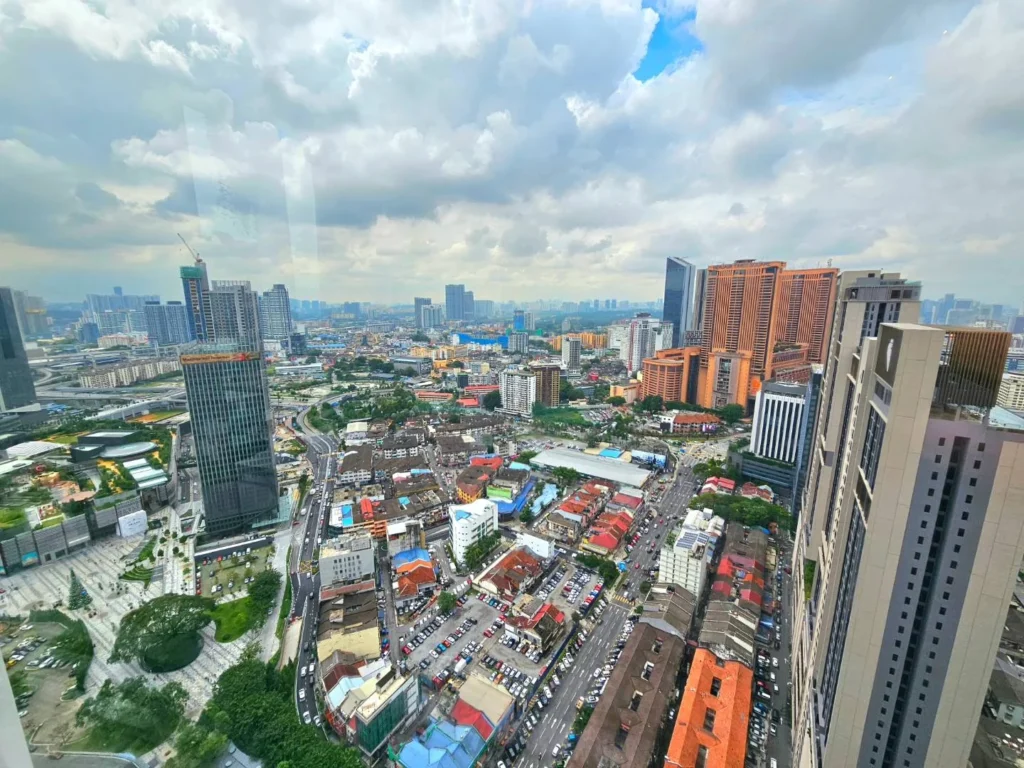 Cruising with Danny and Peter, Holland America Line, Westerdam, Port Kelang, Kuala Lumpur, Malaysia | Port Klang harbor bustling with cargo ships, vibrant staircase leading up to Batu Caves with colorful Hindu art, iconic Petronas Twin Towers towering over Kuala Lumpur’s skyline, panoramic view from KL Tower observation deck showcasing the cityscape, and historical artifacts at the National Museum illustrating Malaysia’s cultural heritage.
