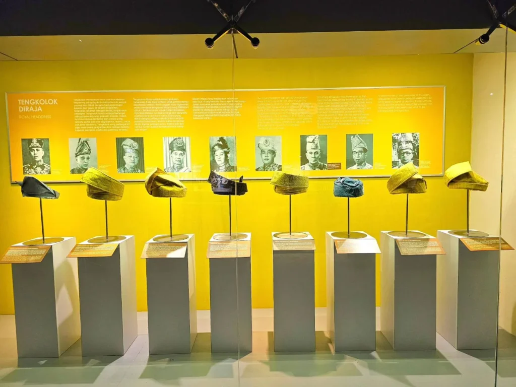 Cruising with Danny and Peter, Holland America Line, Westerdam, Port Kelang, Kuala Lumpur, Malaysia | Port Klang harbor bustling with cargo ships, vibrant staircase leading up to Batu Caves with colorful Hindu art, iconic Petronas Twin Towers towering over Kuala Lumpur’s skyline, panoramic view from KL Tower observation deck showcasing the cityscape, and historical artifacts at the National Museum illustrating Malaysia’s cultural heritage.