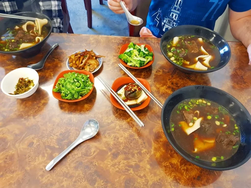 Cruising with Danny and Peter, Holland America Line, Westerdam, Kaohsiung, Taiwan | A serene Buddhist temple in Kaohsiung, showcasing intricate artwork and vibrant colors, representing the city's cultural heritage; beautiful views of Lotus Lake with picturesque pagodas and blooming lotus flowers, capturing the stunning natural landscapes; a bustling street food market with vendors offering local delicacies, highlighting Kaohsiung's vibrant local cuisine and inviting visitors to join a memorable street food tour.