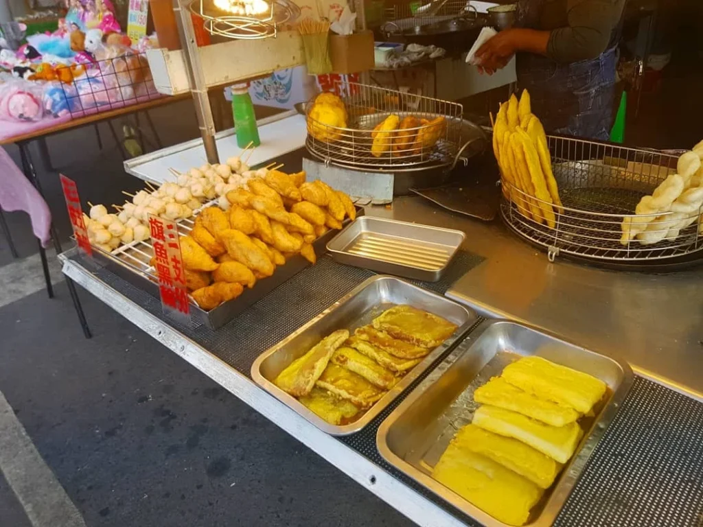 Cruising with Danny and Peter, Holland America Line, Westerdam, Kaohsiung, Taiwan | A serene Buddhist temple in Kaohsiung, showcasing intricate artwork and vibrant colors, representing the city's cultural heritage; beautiful views of Lotus Lake with picturesque pagodas and blooming lotus flowers, capturing the stunning natural landscapes; a bustling street food market with vendors offering local delicacies, highlighting Kaohsiung's vibrant local cuisine and inviting visitors to join a memorable street food tour.