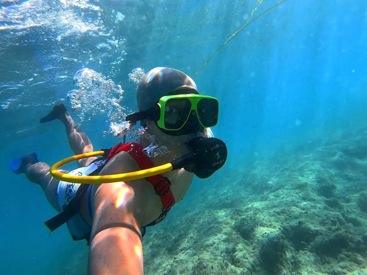 Cruising with Danny and Peter, Holland America Line, Zuiderdam, Grand Turk, Turks And Caicos | A group of adventurers enjoying a Snuba adventure in Grand Turk, exploring vibrant marine life and colorful coral reefs. The clear turquoise waters showcase the underwater ecosystem as participants breathe effortlessly through their Snuba equipment, immersing themselves in this unforgettable Caribbean snorkeling experience.