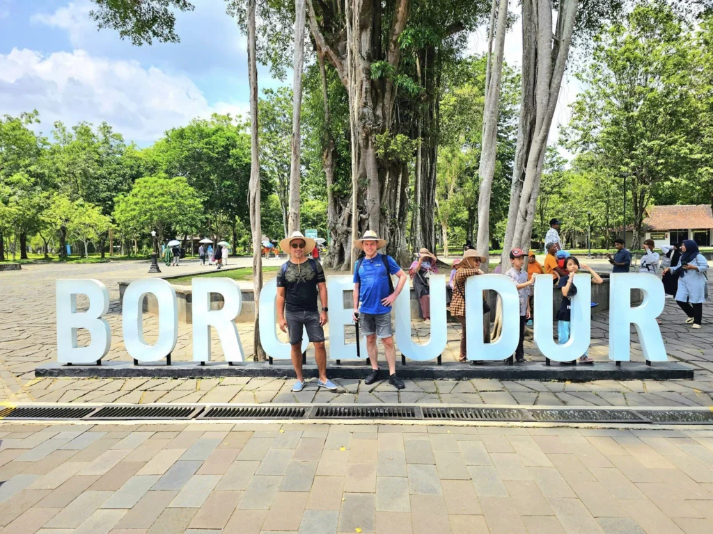 Cruising with Danny and Peter, Holland America Line, Westerdam, Semarang, Java, Indonesia, Borobudur Temple Cruise, Java Adventure | Panoramic view of Borobudur during a Borobudur Temple Cruise, showcasing the UNESCO Buddhist Temple amidst Central Java’s lush hills, with the Westerdam ship docked for the Holland America Westerdam Borobudur Tour, a Luxury Cruise Java adventure in Holland America Far East. Close-up of stupas and Buddha statues at Borobudur, reflecting Mahayana Buddhist Heritage, alongside a vibrant market scene from a Semarang Java Tour, part of an Indonesian Cultural Journey. Travelers explore this Borobudur Pilgrimage Site on a Central Java Travel excursion, enjoying a stunning sunset over the 9th-Century Temple Exploration, with detailed stone reliefs of the UNESCO Buddhist Temple and relaxation on the Westerdam deck during a Westerdam Cruise Indonesia.