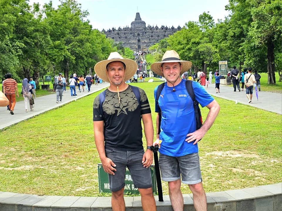 Cruising with Danny and Peter, Holland America Line, Westerdam, Semarang, Java, Indonesia, Borobudur Temple Cruise, Java Adventure | Panoramic view of Borobudur during a Borobudur Temple Cruise, showcasing the UNESCO Buddhist Temple amidst Central Java’s lush hills, with the Westerdam ship docked for the Holland America Westerdam Borobudur Tour, a Luxury Cruise Java adventure in Holland America Far East. Close-up of stupas and Buddha statues at Borobudur, reflecting Mahayana Buddhist Heritage, alongside a vibrant market scene from a Semarang Java Tour, part of an Indonesian Cultural Journey. Travelers explore this Borobudur Pilgrimage Site on a Central Java Travel excursion, enjoying a stunning sunset over the 9th-Century Temple Exploration, with detailed stone reliefs of the UNESCO Buddhist Temple and relaxation on the Westerdam deck during a Westerdam Cruise Indonesia.