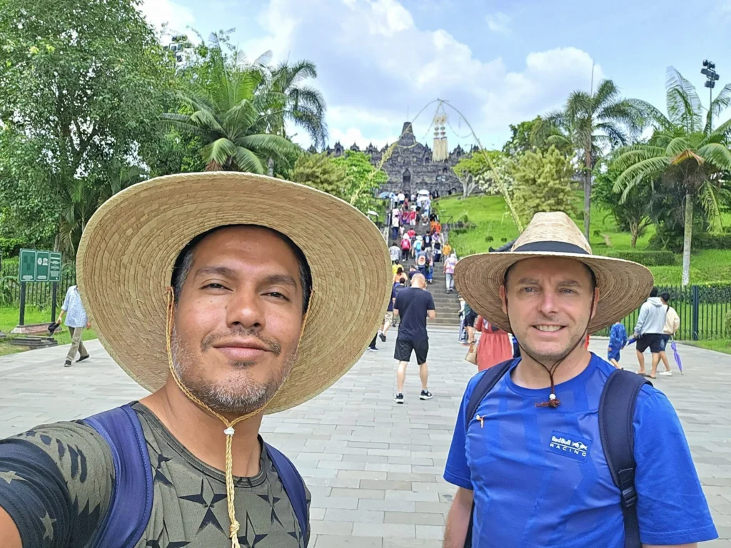 Cruising with Danny and Peter, Holland America Line, Westerdam, Semarang, Java, Indonesia, Borobudur Temple Cruise, Java Adventure | Panoramic view of Borobudur during a Borobudur Temple Cruise, showcasing the UNESCO Buddhist Temple amidst Central Java’s lush hills, with the Westerdam ship docked for the Holland America Westerdam Borobudur Tour, a Luxury Cruise Java adventure in Holland America Far East. Close-up of stupas and Buddha statues at Borobudur, reflecting Mahayana Buddhist Heritage, alongside a vibrant market scene from a Semarang Java Tour, part of an Indonesian Cultural Journey. Travelers explore this Borobudur Pilgrimage Site on a Central Java Travel excursion, enjoying a stunning sunset over the 9th-Century Temple Exploration, with detailed stone reliefs of the UNESCO Buddhist Temple and relaxation on the Westerdam deck during a Westerdam Cruise Indonesia.