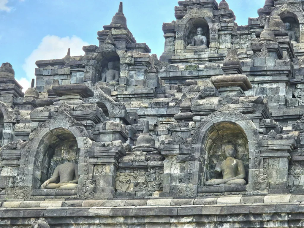 Cruising with Danny and Peter, Holland America Line, Westerdam, Semarang, Java, Indonesia, Borobudur Temple Cruise, Java Adventure | Panoramic view of Borobudur during a Borobudur Temple Cruise, showcasing the UNESCO Buddhist Temple amidst Central Java’s lush hills, with the Westerdam ship docked for the Holland America Westerdam Borobudur Tour, a Luxury Cruise Java adventure in Holland America Far East. Close-up of stupas and Buddha statues at Borobudur, reflecting Mahayana Buddhist Heritage, alongside a vibrant market scene from a Semarang Java Tour, part of an Indonesian Cultural Journey. Travelers explore this Borobudur Pilgrimage Site on a Central Java Travel excursion, enjoying a stunning sunset over the 9th-Century Temple Exploration, with detailed stone reliefs of the UNESCO Buddhist Temple and relaxation on the Westerdam deck during a Westerdam Cruise Indonesia.